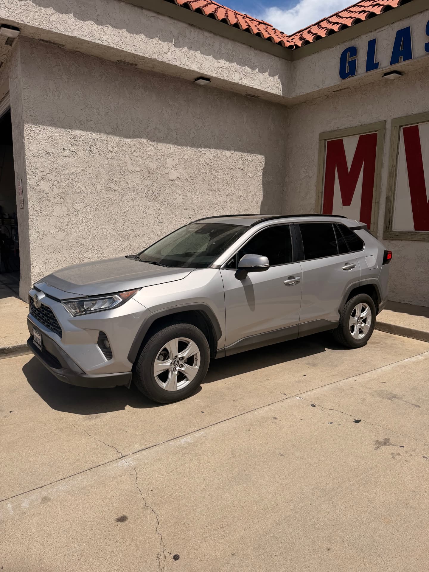 Silver Toyota RAV4 with freshly tinted windows outside the shop
